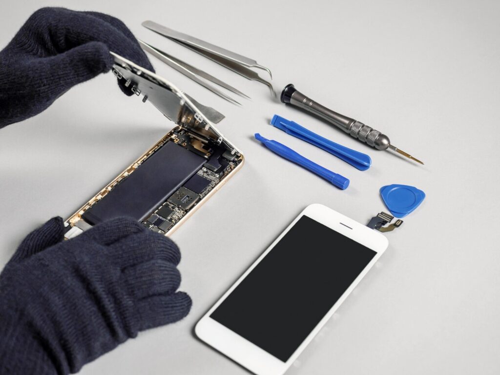 Technician repairing broken smartphone desk 77206 240