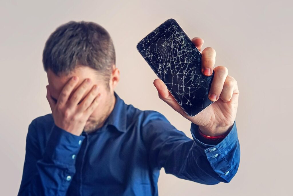 Guy is holding black smartphone with broken display 431724 8616 Guy is holding black smartphone with broken display 431724 8616