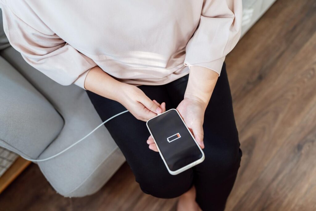 Woman hands charging mobile phone battery with low battery plugging charger smart phone with energy bank powerbank power charger modern lifestyle energy technology concept 1715 14489