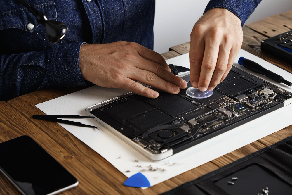 homem realizando manutenção em macbook